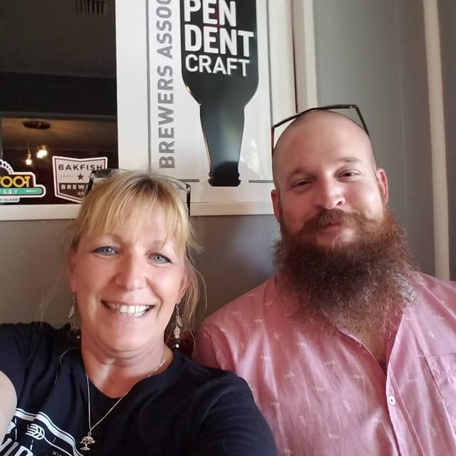 Two people smiling together inside the taproom